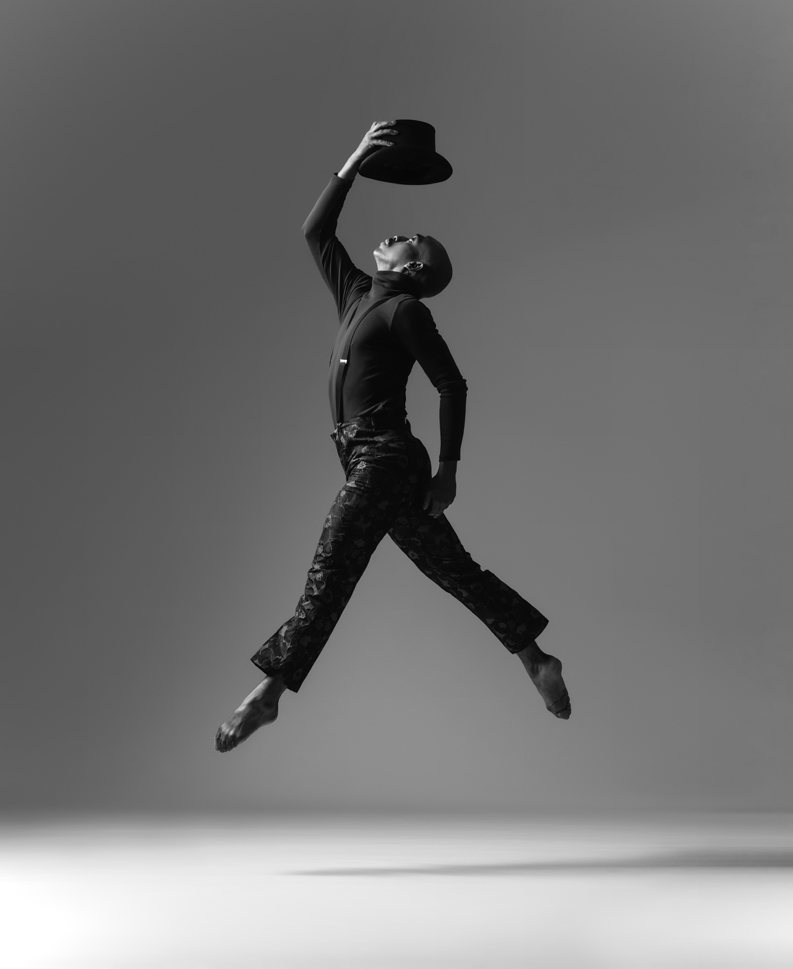 Dancer Maurice mid-leap with top hat raised