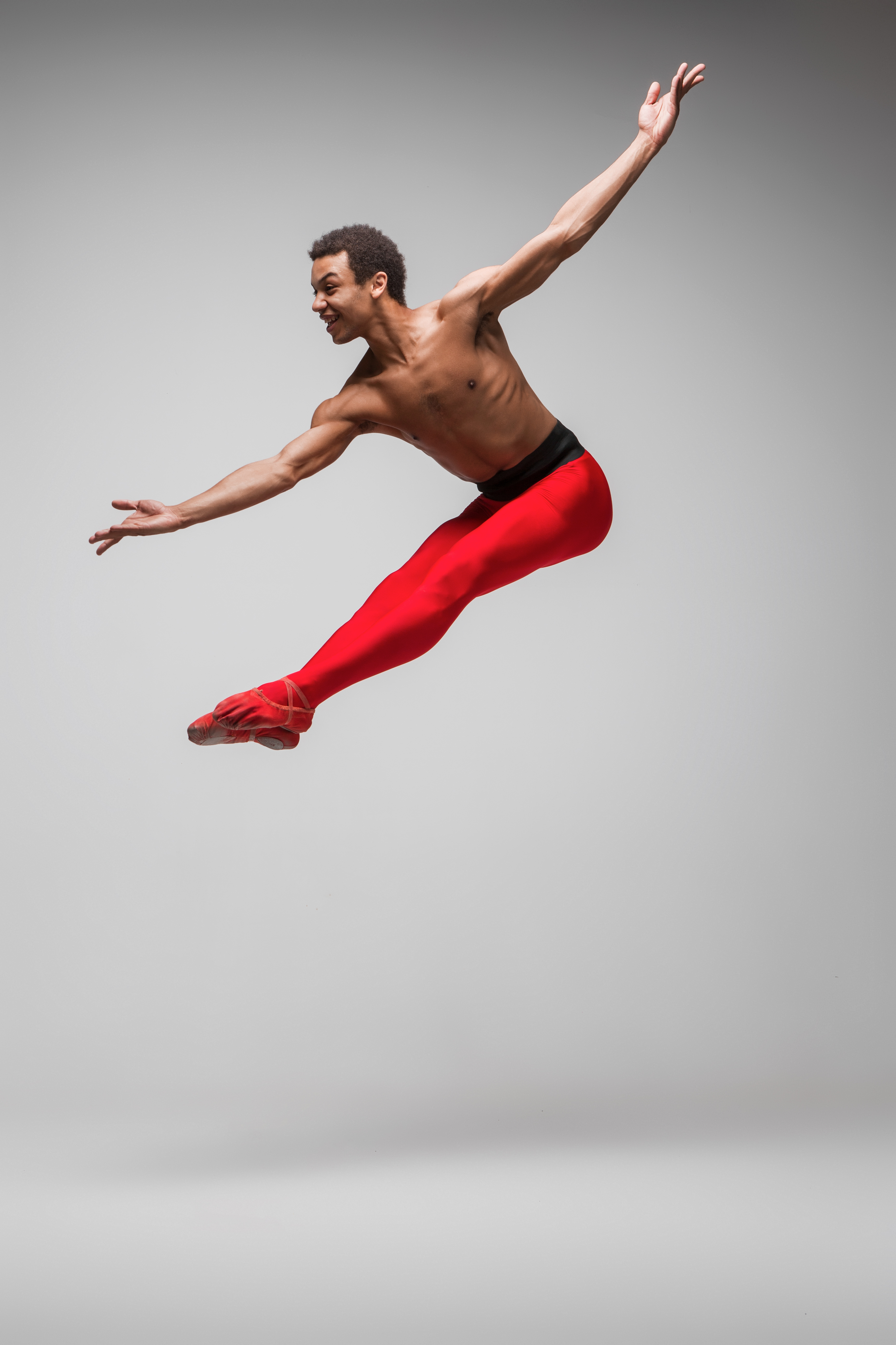 Dancer mid-leap on a studio backdrop